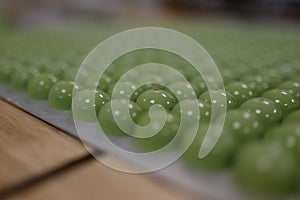 Green Princess cake Pralines arranged in a row.