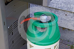 Green propane gas connected to a grill