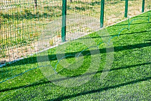 Green protective grid close-up. The pattern of a protective grid for a sports ground. Sports background