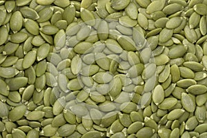 Green pumpkin seeds background. Top view