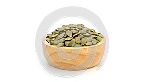 Green pumpkin seeds in a bowl on a white background