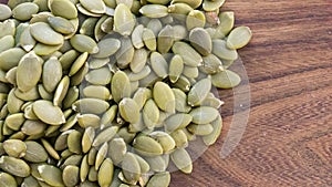 Green pumpkin seeds on wooden white background. Copy space