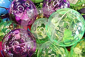 Green and purple bounce balls in a pile