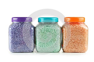 Green, purple, orange sea salt in bottles isolated on a white