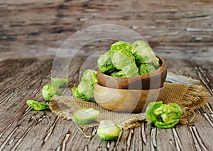 Green raw Brussels sprouts in wooden bowl , selective focus