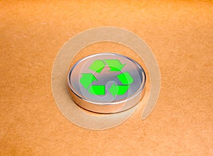 Green recycle icon symbol on round silver plate on brown kraft paper background. Ecology, sustainability cooperation, reduce,