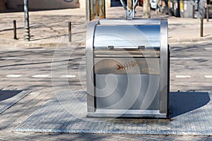 Green recycling container on a city street, inviting people to dispose of their organic waste responsibly