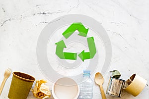 Recycling symbol and different garbage, paper cup, plastic bottle, can for ecology on marble background top view