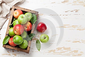 Green and red apples in wooden box