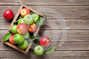 Green and red apples in wooden box