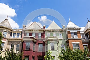 Green, red, and orange row houses in Washington DC on a summer day.