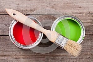 Green and red paint in the bank to repair and brush on the old wooden background