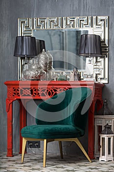 Green retro chair near the red dressing table