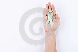 Green ribbon over palm. White background