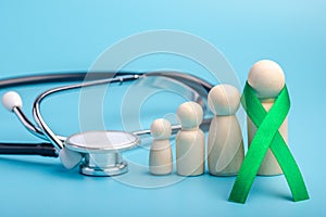 Green ribbon and stethoscope.treatment concept for ovarian cancer and cervical cancer photo