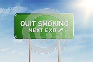 Green road sign with text of quit smoking