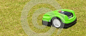 Green robot lawn mower on the lawn