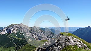 Green and rocky mountain landscape in the Swiss Alps with a weather station on a rocky peak for measuring weather data and informa photo