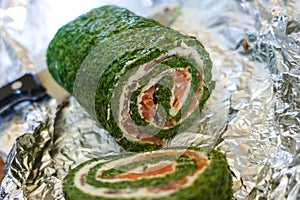 Green roll with fish in foil close up