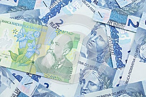 A green Romanian leu bill with Brazilian two reais bank notes