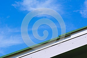 Green roof gable on blue sky and cloud