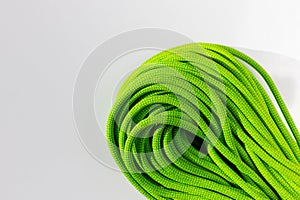 green rope for rock climbing and mountaineering lies on a white background. background image of rope for active sports