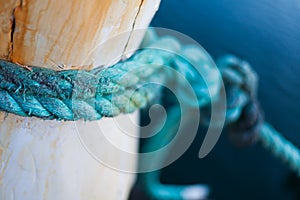 Green rope tied around wooden post