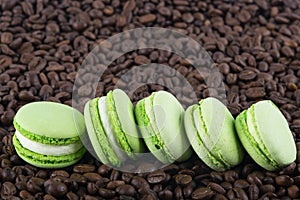 Green round biscuits lie in a row against the background of coffee beans