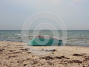 Green Rowing Boat Upside Down on Beach