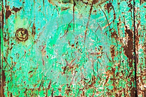 Green rusty and grungy metal iron plate wall with the typical ferric oxide red color and with green peeling coating paint