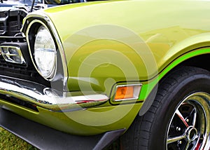 Closeup of a green 1970`s muscle car front end