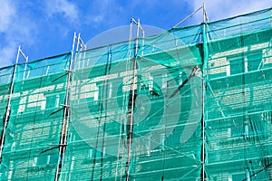 Green safety net on scaffolding at the facade of an apartment house