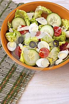 Green salad in bowl on table. Tomato, cucumber and salat