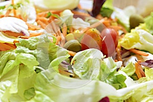 Green salad with carrot, olives, cherry tomatoes and sweet corn