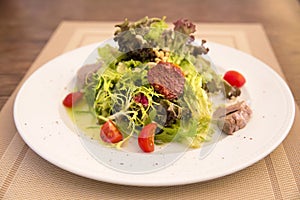 Green salad with chicken meat, dried tomatoes and pine nuts