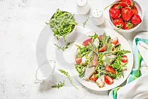 Green salad with chicken, strawberry and arugula.