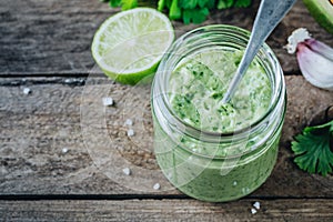 Green salad dressing with avocado, lime and cilantro in a glass jar