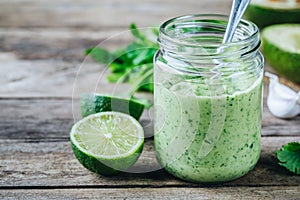 Green salad dressing with avocado, lime and cilantro in a glass jar