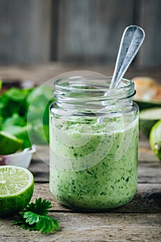 Green salad dressing with avocado, lime and cilantro in a glass jar