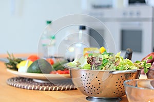 Green salad leaves are on a kitchen