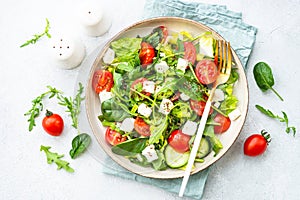 Green salad with spinach, arugula and radish with olive oil.