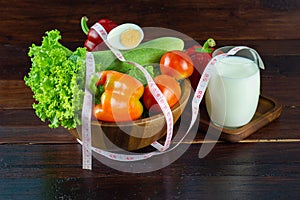 A green salad in wood cup with milk in a glass