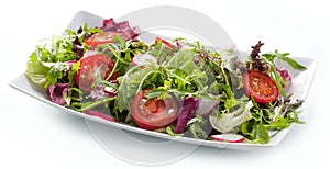 Green salat in a bowl on desk. Tomato, cheese and salad.