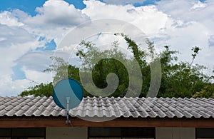 Green Satellite dish on the roof with a beautiful blue sky.