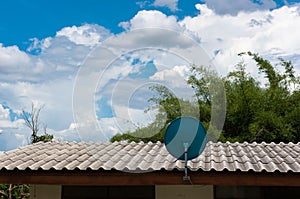 Green Satellite dish on the roof with a beautiful blue sky.