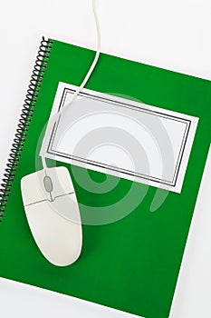 Green school textbook and computer mouse