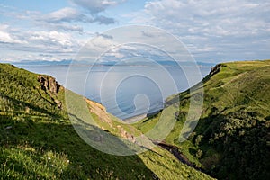 Zelený skotský kopce a hluboký nejblíže na ostrůvek z pastviny během západ slunce 