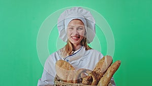 Green screen concept beautiful blonde lady baker holding a big basket of a fresh French bread in front of the camera she