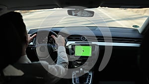 Green screen on dashboard car panel with driving male person on background. Navigating app. Chromakey mockup. Social