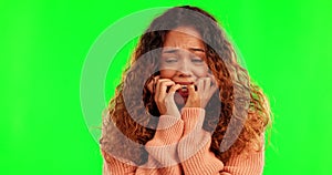 Green screen, face and scared woman biting nails, stress and fear, worry and crisis on studio background. Anxiety